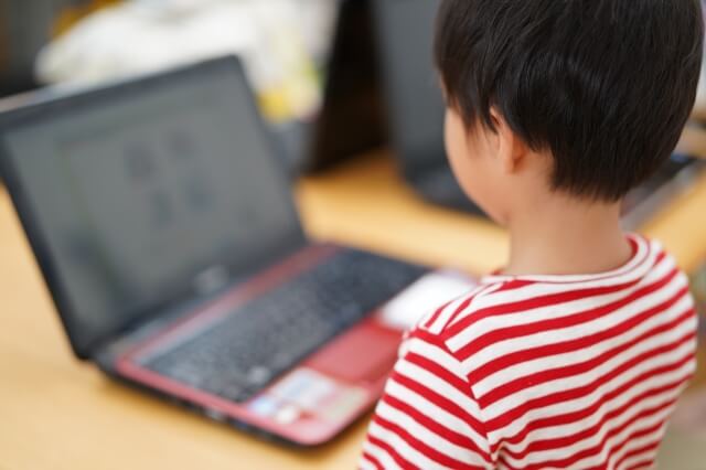 子供がパソコンの画面を見ている画像