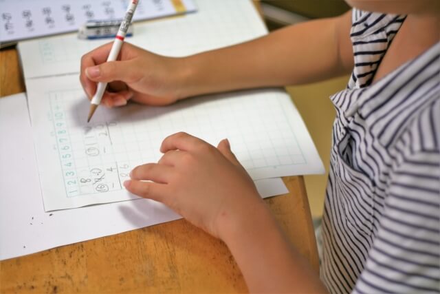 子供がノートに計算式を書いている画像