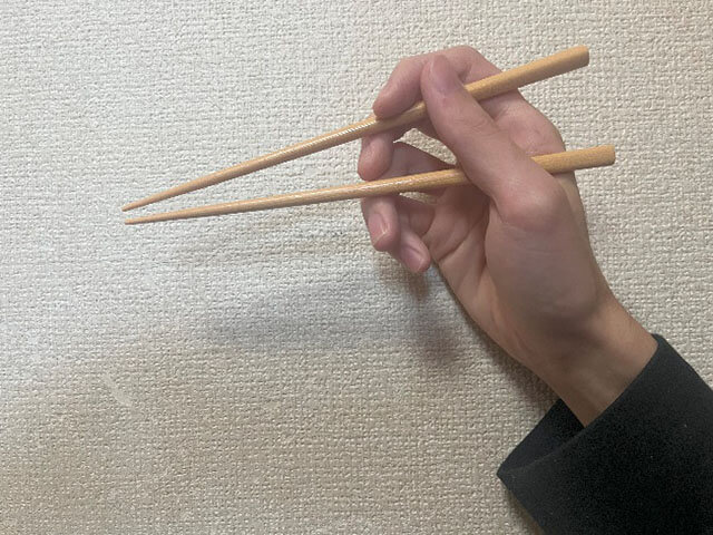 2本箸を持って上の箸だけ下方向に動かしている画像