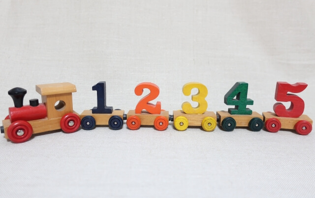 1~5までの数字のプレートが乗っている木製の機関車のおもちゃの画像