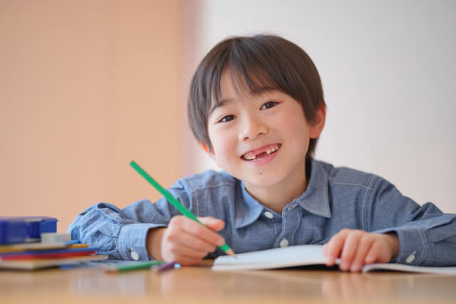 男の子が笑顔で勉強している画像