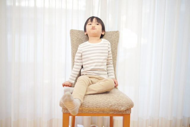 男の子が椅子の上に座っている画像