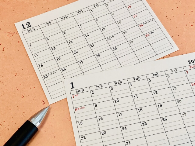 ボールペンの横に12月と1月のカレンダーが置いてある画像