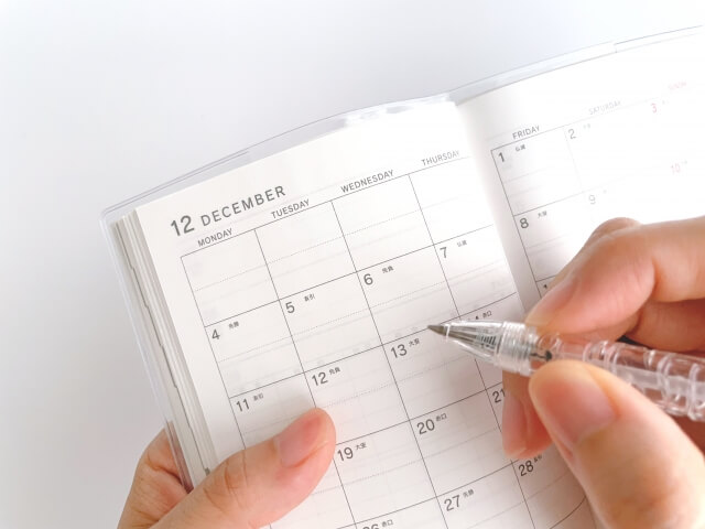 手帳型カレンダーにメモをしている様子の画像