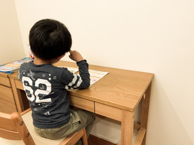 子供が学習机の前に座っている画像