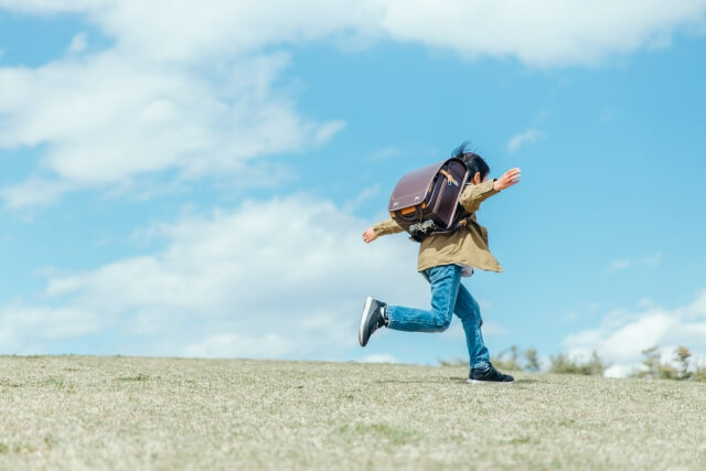 青空の下で子供が走っている様子