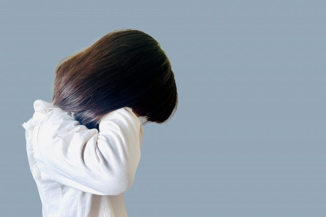目元を手で覆っている女の子の横顔の写真