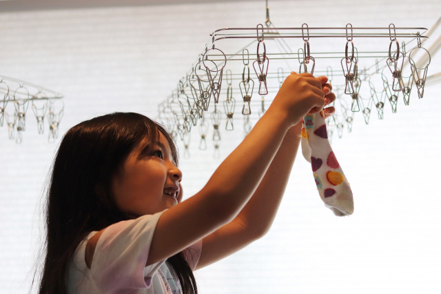 物干しに靴下をかける子どもの画像