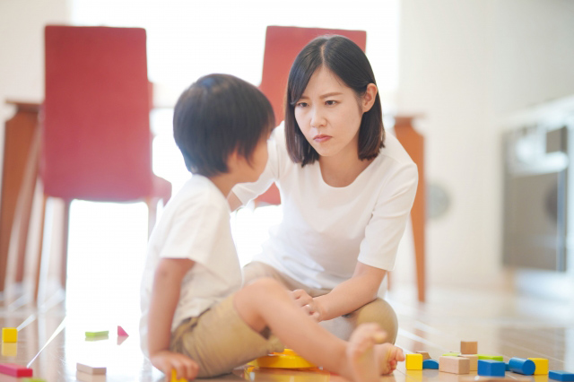 子供に訴えかけるような表情をする母親の画像