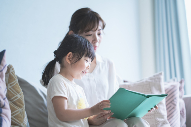 親子で一緒に本を読んでいる画像