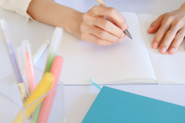 ノートに何かを書こうとしており、手前にペンが置かれている画像