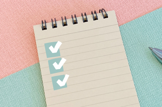 チェックマークが書かれたメモ帳の画像