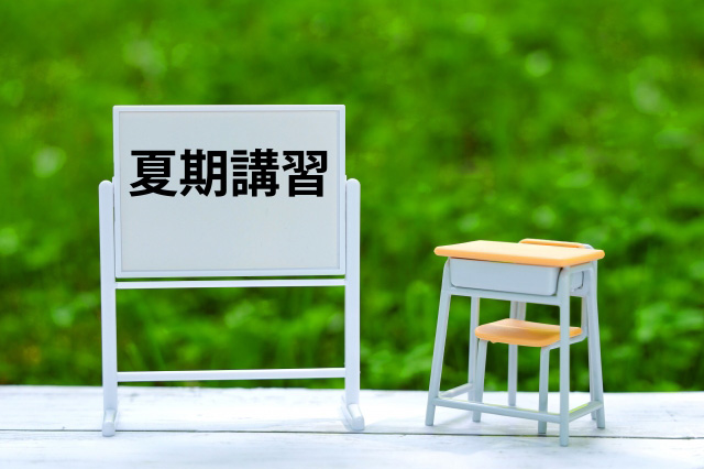 夏期講習と書かれたホワイトボードと勉強机の画像