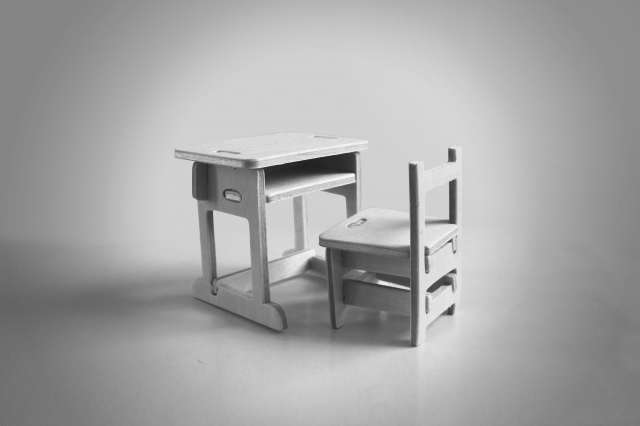 ミニチュアサイズの机といすの白黒写真