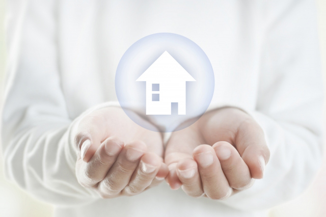 家のイラストを手で受け止めている画像