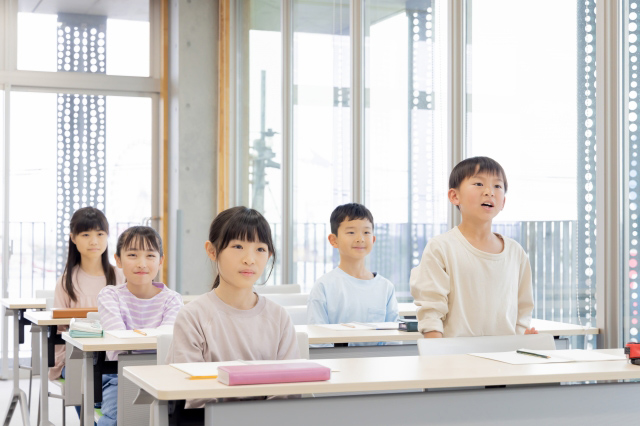 授業中に立って発言をする子供の画像