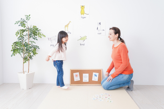 英語の書かれたイラストを英語教師と学ぶ子供のイラスト