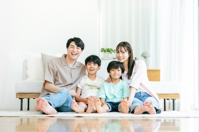 四人家族が横一列に並んで座っている画像