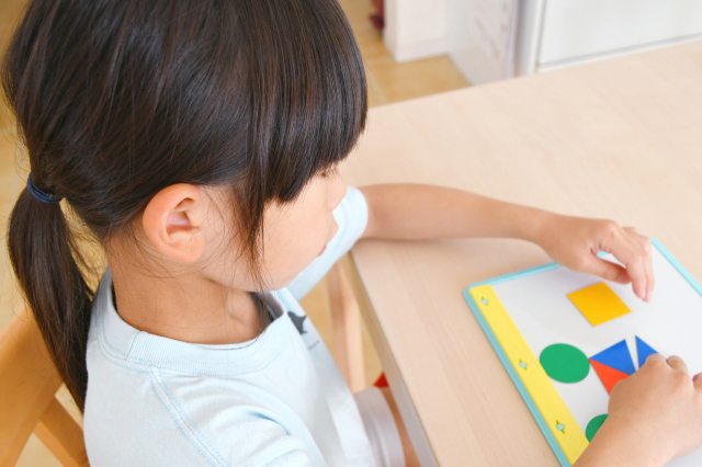 図形パズルで遊ぶ子供のイラスト