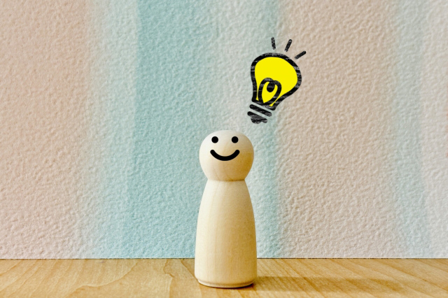 木の人形がひらめきマークを出している画像