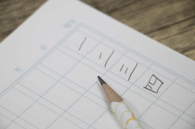 漢数字の練習をしているノートと鉛筆の画像